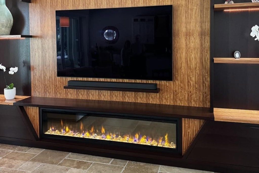 74-inch Dimplex Ignite Evolve electric fireplace with crystal ember media below a TV in a custom wood media wall