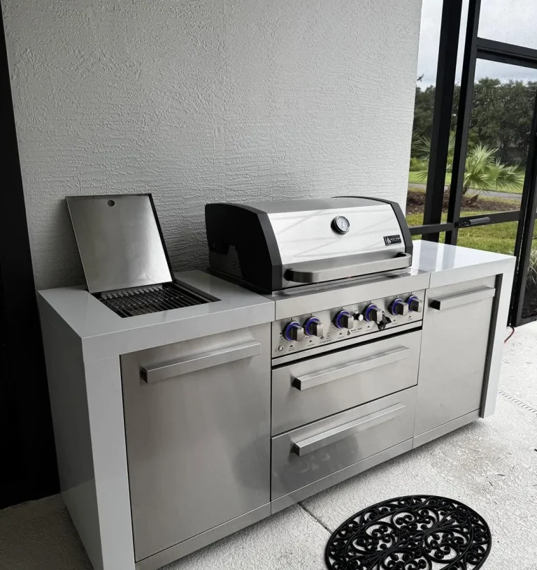 Modular outdoor kitchen with built-in grill, sink and beverage fridge on a screened lanai