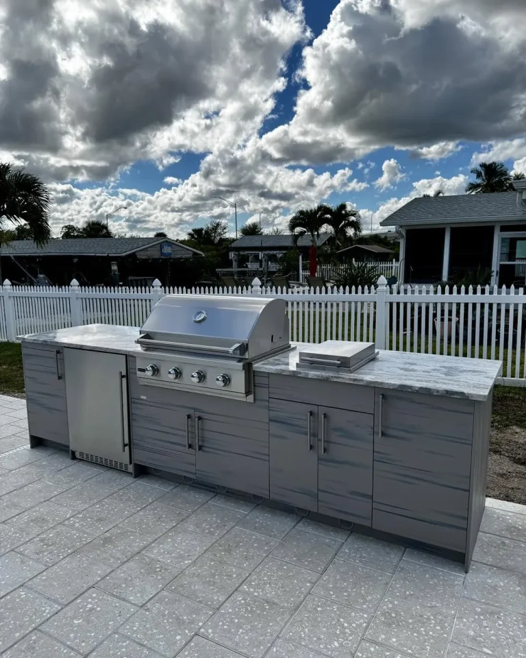 Outdoor kitchen with built-in grill and gray cabinets on a New Smyrna Beach patio