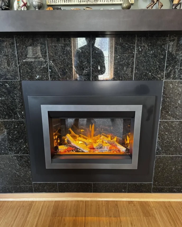 Valor electric fireplace insert with black surround in a granite wall